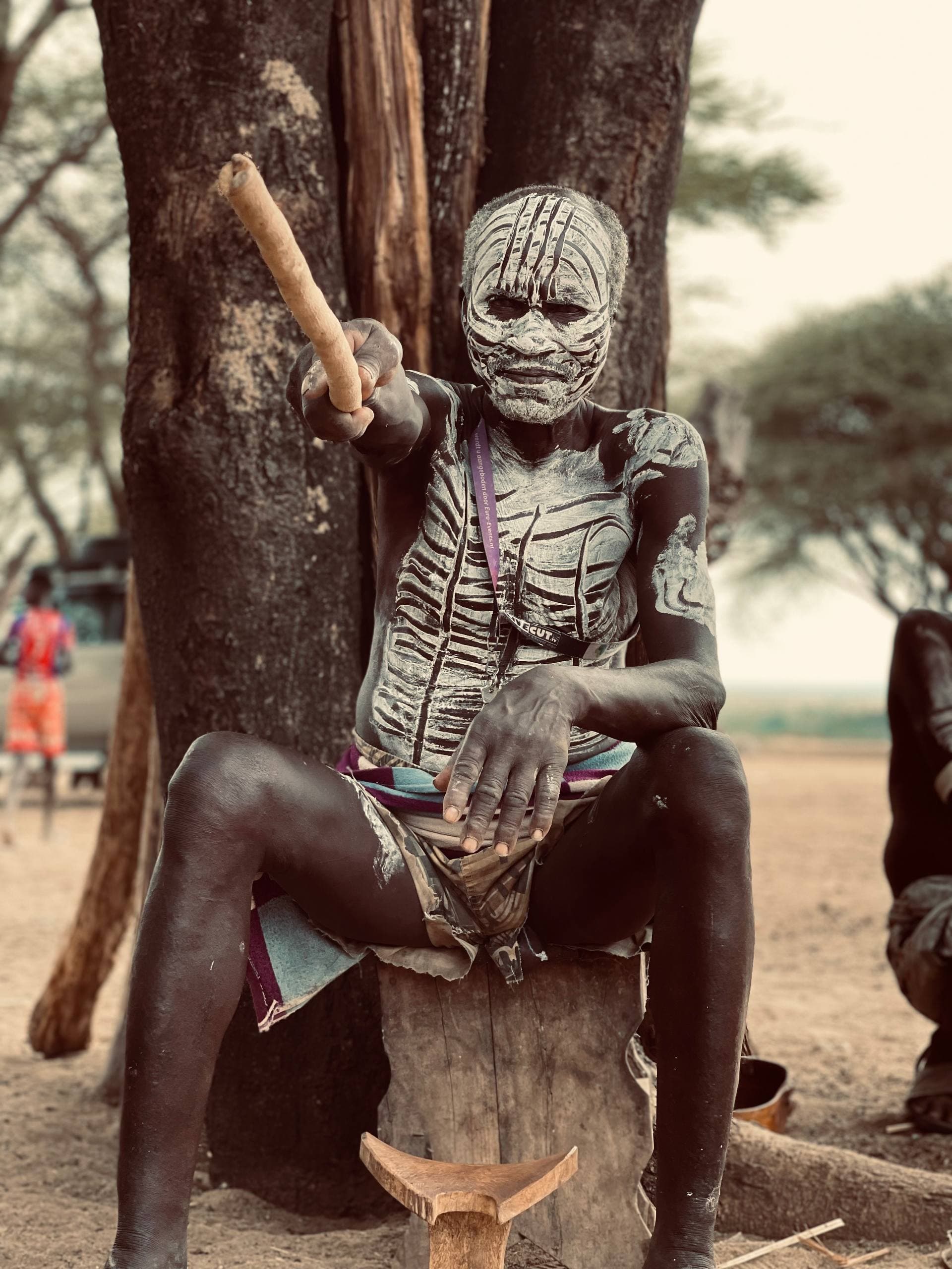 A cinematic, high-resolution wide shot of a traditional tribal ceremony in the Omo Valley at dusk